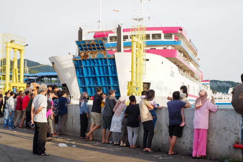 Vista di molte persone che guardano un traghetto ormeggiato nel porto di merak nel pomeriggio immagini stock
