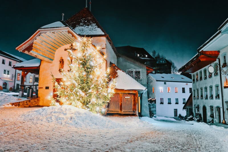 Vista di notte della via illuminata dell'albero di abete di Natale di Gruyeres immagini stock libere da diritti Vista di notte della via illuminata dell'albero di abete di Natale di Gruyeres immagini stock libere da diritti