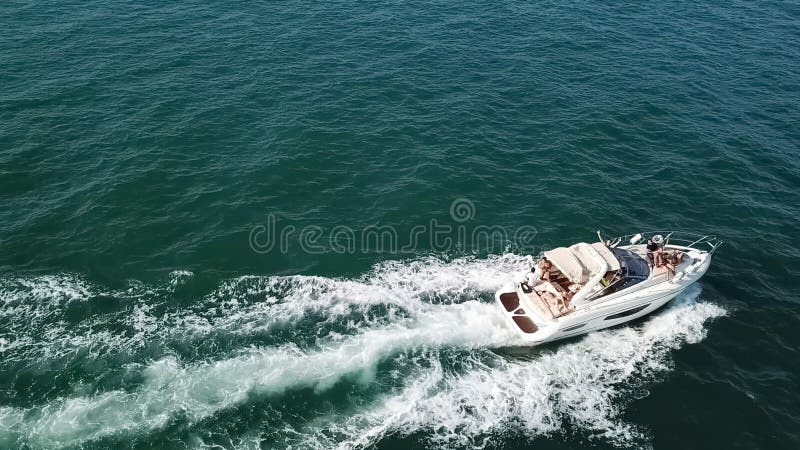 Cabo Ledo / Angola - 12/20/2019: View of a private recreational boat with people sailing, yacht speeding by the coast at Cabo Ledo in Angola. Cabo Ledo / Angola - 12/20/2019: View of a private recreational boat with people sailing, yacht speeding by the coast at Cabo Ledo in Angola