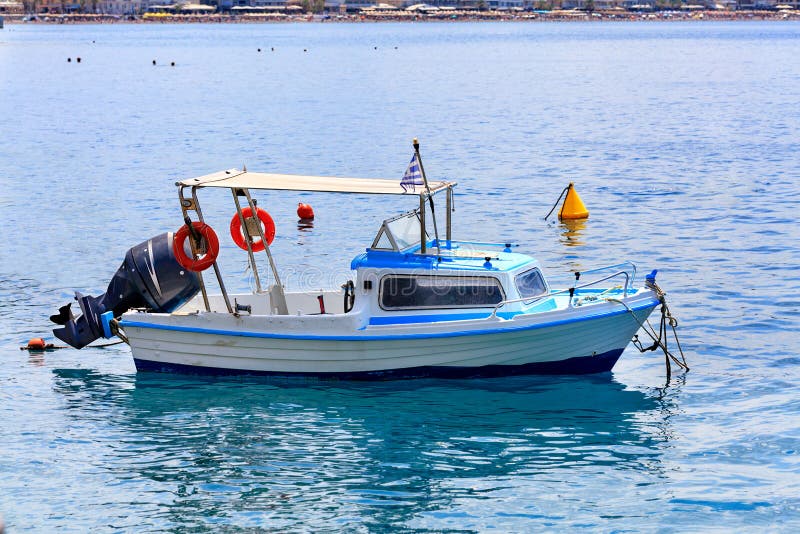 Vista di una piccola imbarcazione di soccorso con un potente motore sullo sfondo della costa sulla spiaggia immagine stock Vista di una piccola imbarcazione di soccorso con un potente motore sullo sfondo della costa sulla spiaggia immagine stock