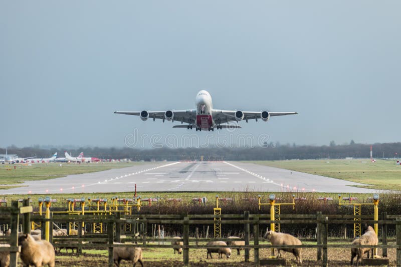 Vista diretamente abaixo da pista de decolagem como um plano da linha aérea dos emirados decola do título do aeroporto de Londres