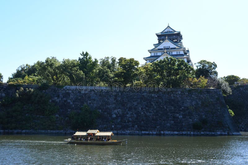 Vista do Castelo de Osaka com um barco de turistas a passar foto de stock royalty free