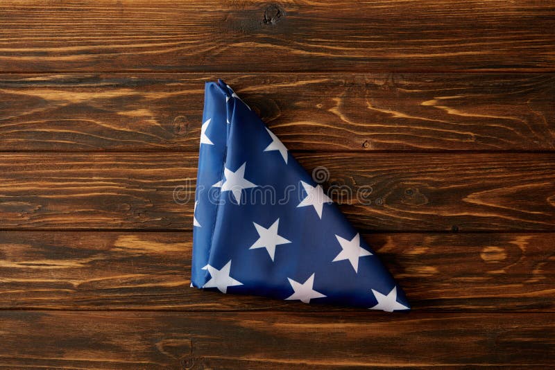 vista elevado da bandeira dobrada de Estados Unidos na superfície de madeira