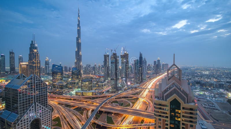 Vista em arranha-céus modernos e dia ocupado das estradas da noite ao timelapse da noite na cidade luxuosa de Dubai, Dubai, árabe