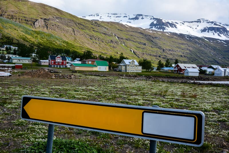 Vista escénica de la pequeña ciudad Seydisfjordur en Islandia del este en verano con nieve en las montañas foto de archivo libre de regalías Vista escénica de la pequeña ciudad Seydisfjordur en Islandia del este en verano con nieve en las montañas foto de archivo libre de regalías