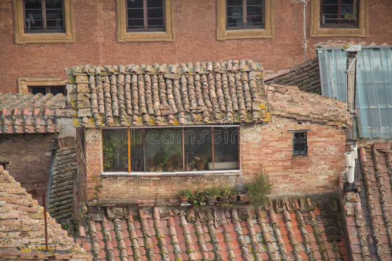 Vista exterior de um sótão em uma casa antiga em Siena, Toscânia, Itália imagem de stock royalty free Vista exterior de um sótão em uma casa antiga em Siena, Toscânia, Itália imagem de stock royalty free