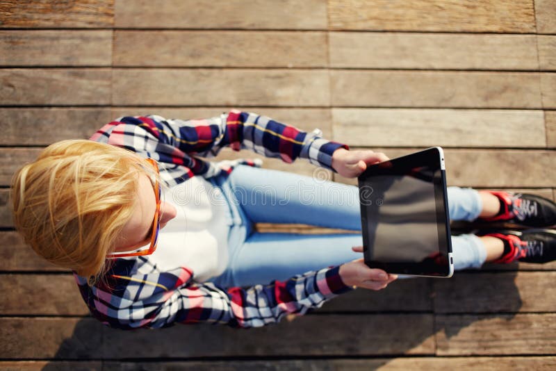 Vista fotografante turistica femminile sveglia che si siede sul pavimento di legno all'aperto fotografie stock libere da diritti Vista fotografante turistica femminile sveglia che si siede sul pavimento di legno all'aperto fotografie stock libere da diritti