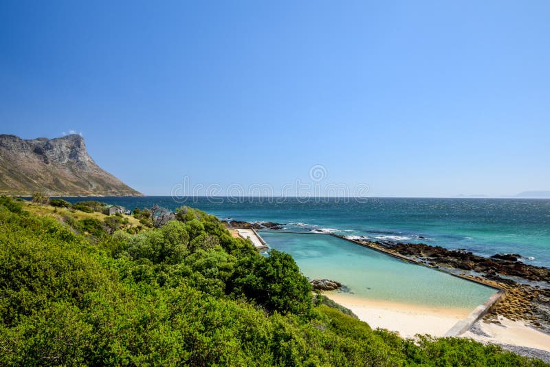 Stunning view of Route 44 in the eastern part of False Bay near Cape Town between Gordon`s Bay and Pringle Bay. Hottentots Holland Mountain range in the background. Viewpoint parking bay on right. Stunning view of Route 44 in the eastern part of False Bay near Cape Town between Gordon`s Bay and Pringle Bay. Hottentots Holland Mountain range in the background. Viewpoint parking bay on right.