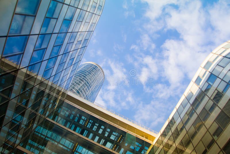 Vista inferior de los rascacielos de cristal del distrito financiero de la defensa del La de París contra un cielo nublado azul fotografía de archivo Vista inferior de los rascacielos de cristal del distrito financiero de la defensa del La de París contra un cielo nublado azul fotografía de archivo