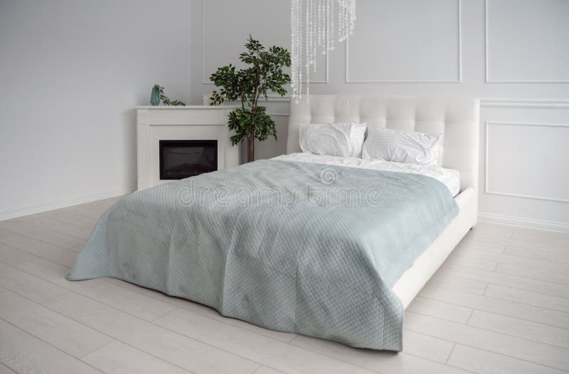 Vista lateral da cama de couro branca com bedsheet e a chamin? azuis imagens de stock royalty free Vista lateral da cama de couro branca com bedsheet e a chamin? azuis imagens de stock royalty free