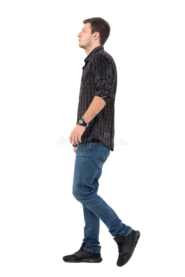 Vista lateral de los vaqueros del hombre joven y de caminar de la camisa que llevan imagen de archivo libre de regalías Vista lateral de los vaqueros del hombre joven y de caminar de la camisa que llevan imagen de archivo libre de regalías