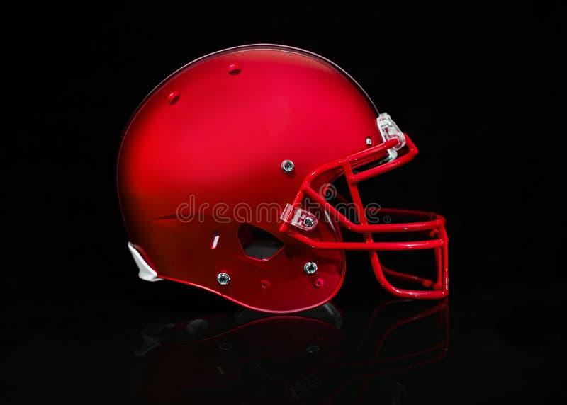 Vista lateral de um capacete de futebol vermelho em um fundo preto fotos de stock royalty free Vista lateral de um capacete de futebol vermelho em um fundo preto fotos de stock royalty free