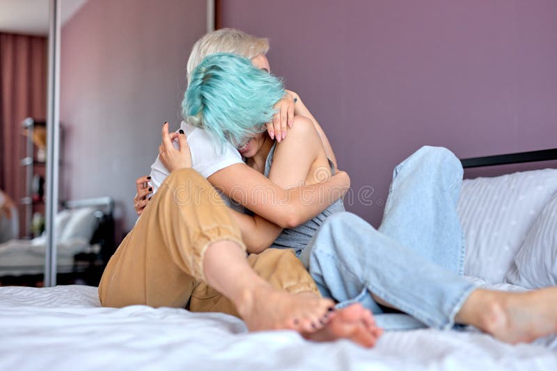 Pareja De Lesbianas Cariñosas Abrazándose En El Sofá Pies Cerrando Espacio De Copia Foto de