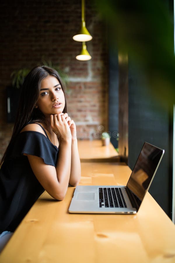 Vista lateral La mujer joven que se sienta en la tabla en café y hace notas en cuaderno En línea aprendiendo Estudiante que hace imagen de archivo libre de regalías Vista lateral La mujer joven que se sienta en la tabla en café y hace notas en cuaderno En línea aprendiendo Estudiante que hace imagen de archivo libre de regalías