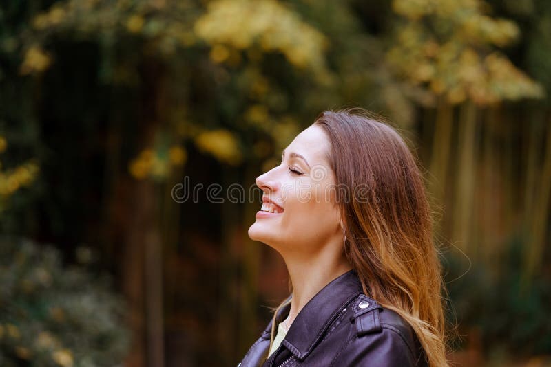 Vista laterale della giovane signora felice che tiene gli occhi chiuso e sorridere fotografie stock libere da diritti