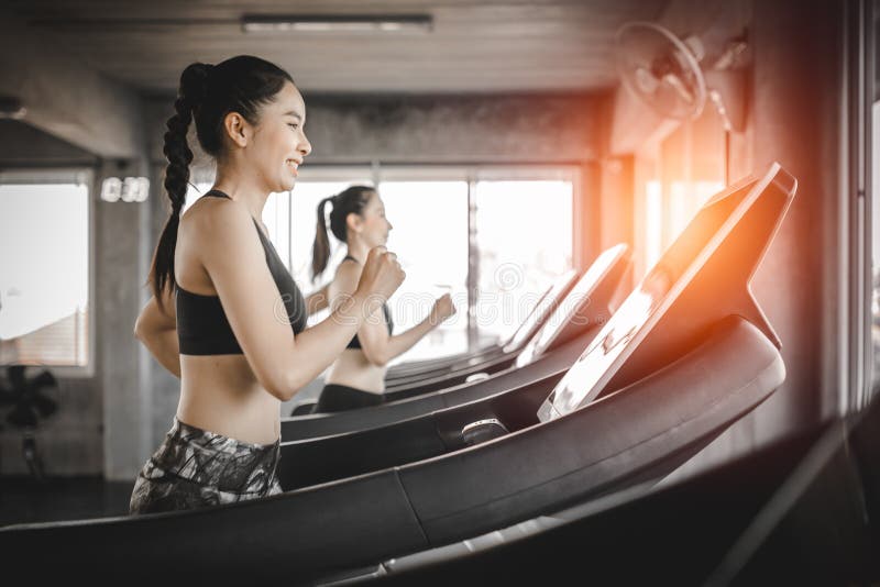 Vista laterale delle donne attraenti di sport sulla pista corrente Sano, sport, stile di vita, concetto di forma fisica fotografie stock Vista laterale delle donne attraenti di sport sulla pista corrente Sano, sport, stile di vita, concetto di forma fisica fotografie stock