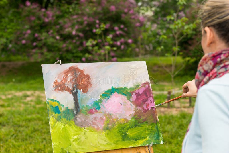 Vista laterale di una pittura femminile dell'artista fotografia stock libera da diritti Vista laterale di una pittura femminile dell'artista fotografia stock libera da diritti