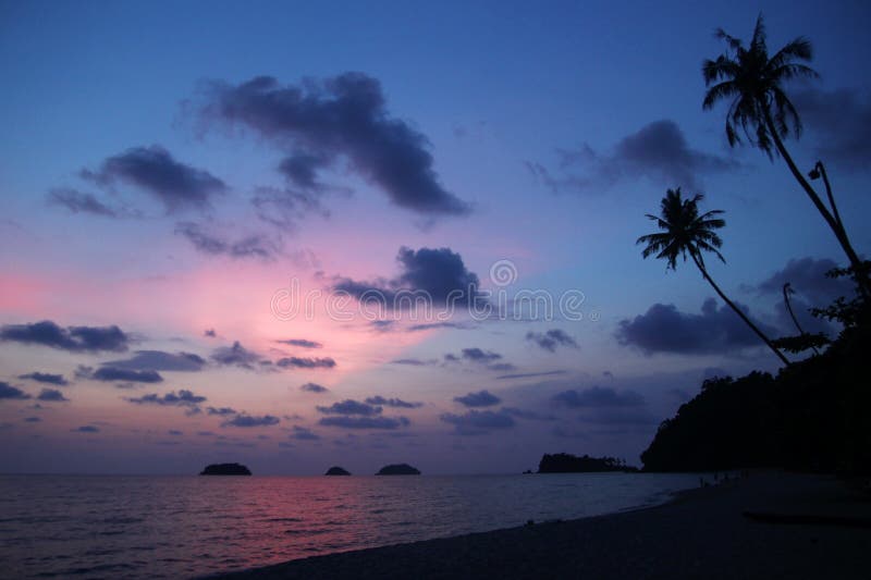Vista no céu e no mar do por do sol com árvores de palmas uma praia Koh Chang, Tail?ndia foto de stock royalty free Vista no céu e no mar do por do sol com árvores de palmas uma praia Koh Chang, Tail?ndia foto de stock royalty free
