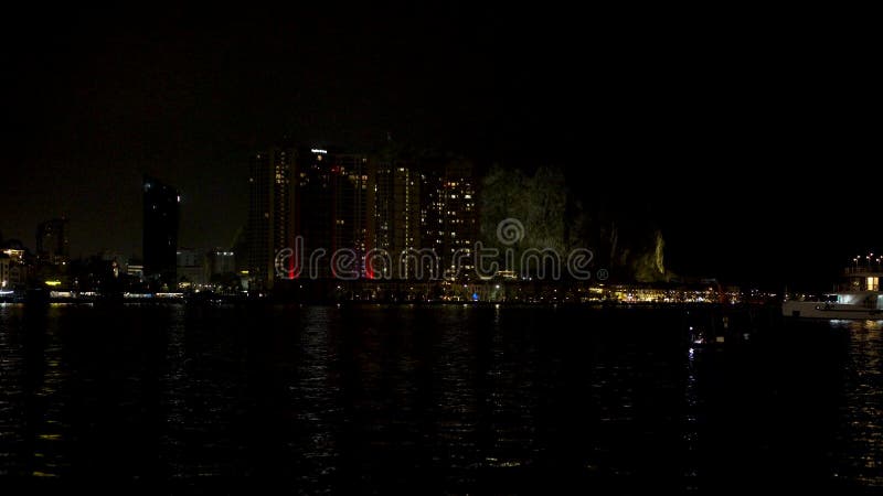 Vista nocturna de una ciudad costera con luces que reflejan el agua almacen de metraje de vídeo