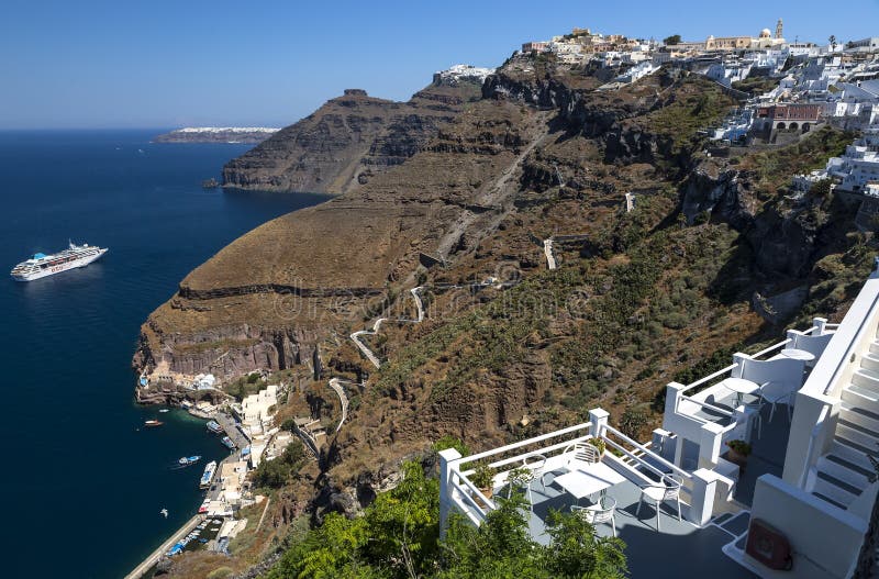 Vista panor?mica de Fira, ilha de Santorini com trajeto do asno e telef?rico do porto velho, rochas vulc?nicas altas em Gr?cia