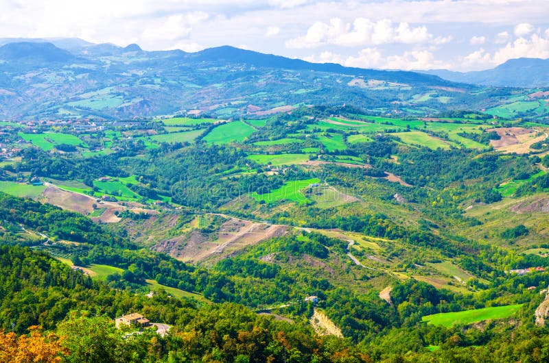 Vista panoramica superiore aerea di paesaggio con la valle, le colline verdi, i campi ed i villaggi della Repubblica San Marino fotografie stock Vista panoramica superiore aerea di paesaggio con la valle, le colline verdi, i campi ed i villaggi della Repubblica San Marino fotografie stock