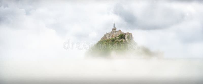 Vista panorámica de la isla de marea famosa de Le Mont Saint-Michel en un día de la niebla, Normandía, Francia septentrional imagen de archivo Vista panorámica de la isla de marea famosa de Le Mont Saint-Michel en un día de la niebla, Normandía, Francia septentrional imagen de archivo