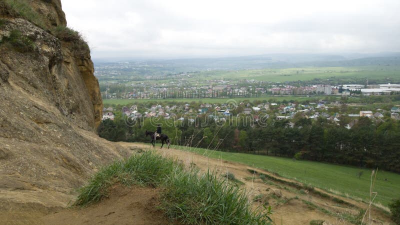 Vista panorámica de los campos cercanos a la ciudad turística de Kislovodsk Montañas y un jinete sobre un caballo en el fondo imágenes de archivo libres de regalías Vista panorámica de los campos cercanos a la ciudad turística de Kislovodsk Montañas y un jinete sobre un caballo en el fondo imágenes de archivo libres de regalías