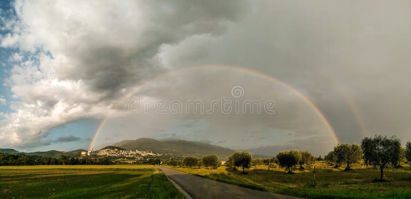 Vista panorámica hermosa de un arco iris sobre la ciudad Umbría, Italia de Assisi fotografía de archivo libre de regalías Vista panorámica hermosa de un arco iris sobre la ciudad Umbría, Italia de Assisi fotografía de archivo libre de regalías