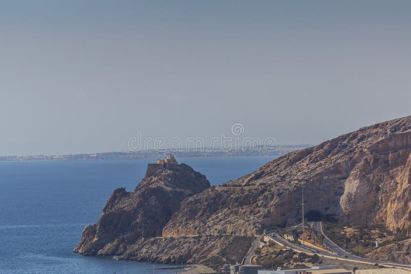 Vista panorámica hermosa de una península montañosa con el castillo de San Telmo y de un túnel con un camino imagen de archivo Vista panorámica hermosa de una península montañosa con el castillo de San Telmo y de un túnel con un camino imagen de archivo