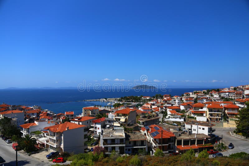 Vista panorâmica dos telhados da terracota da cidade de Grécia e do porto Na distância uma ilha e uma linha do horizonte fotografia de stock Vista panorâmica dos telhados da terracota da cidade de Grécia e do porto Na distância uma ilha e uma linha do horizonte fotografia de stock