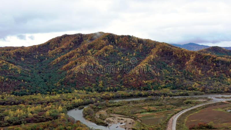 Vista por drones de coloridas montañas con un camino bajo un cielo nublado en el gran cañón de la montaña changbai almacen de metraje de vídeo