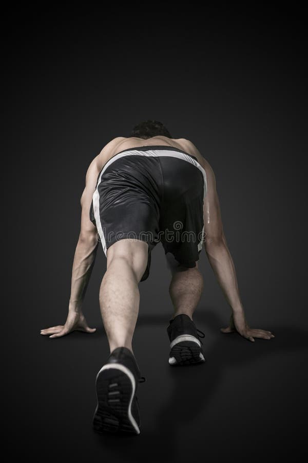 Vista posterior de un hombre musculoso listo para correr fotos de archivo libres de regalías Vista posterior de un hombre musculoso listo para correr fotos de archivo libres de regalías