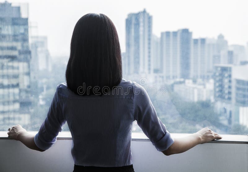 Vista posterior de una empresaria que considera hacia fuera la ventana el paisaje urbano en Pekín, China imagenes de archivo Vista posterior de una empresaria que considera hacia fuera la ventana el paisaje urbano en Pekín, China imagenes de archivo