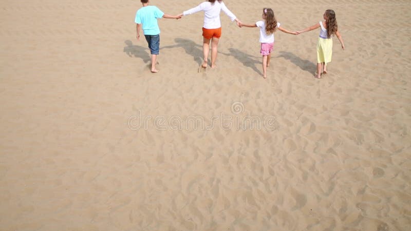Vista posterior de una mujer joven y tres hijos que metrajes