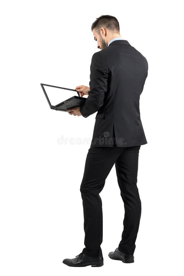 Vista posterior del hombre de negocios que trabaja en un ordenador portátil con la pantalla vacía en blanco foto de archivo Vista posterior del hombre de negocios que trabaja en un ordenador portátil con la pantalla vacía en blanco foto de archivo