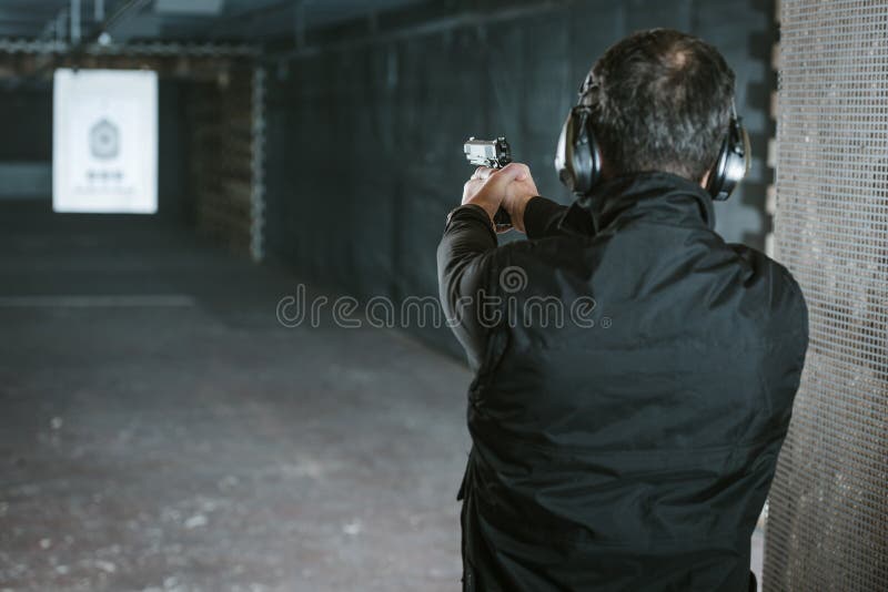 vista posterior del hombre que apunta el arma a la blanco foto de archivo libre de regalías vista posterior del hombre que apunta el arma a la blanco foto de archivo libre de regalías