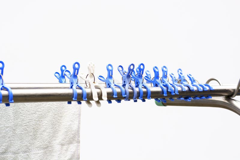 Vista su una fila delle mollette da bucato o delle mollette di plastica blu e bianche, significata per l'essiccamento della lavan fotografia stock Vista su una fila delle mollette da bucato o delle mollette di plastica blu e bianche, significata per l'essiccamento della lavan fotografia stock