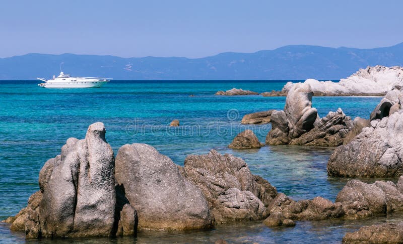 Vista sul mare con belle acqua del turchese, barca e rocce del mare fotografie stock Vista sul mare con belle acqua del turchese, barca e rocce del mare fotografie stock