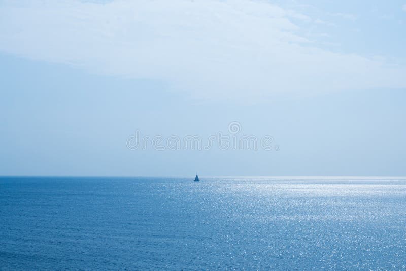 Vista sul mare e una barca a vela fotografia stock Vista sul mare e una barca a vela fotografia stock