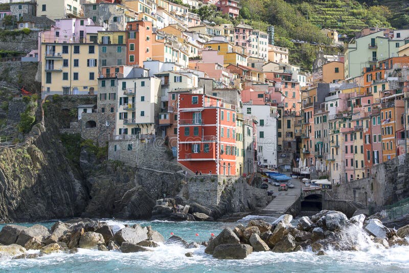 Vista sulla spiaggia e sulle case tipiche in piccolo villaggio, Riomaggiore, Cinque Terre, Italia immagini stock