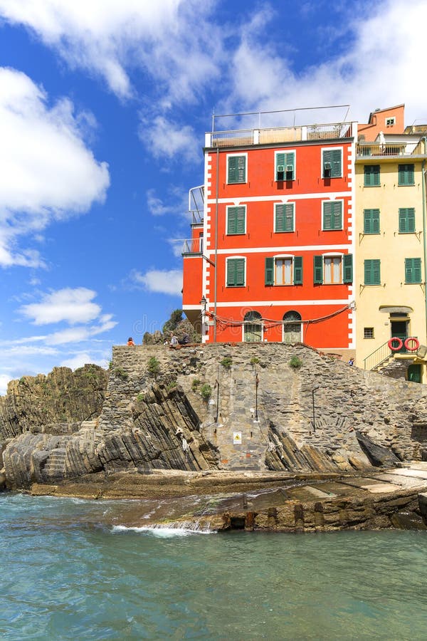 Vista sulla spiaggia e sulle case tipiche in piccolo villaggio, Riomaggiore, Cinque Terre, Italia immagine stock