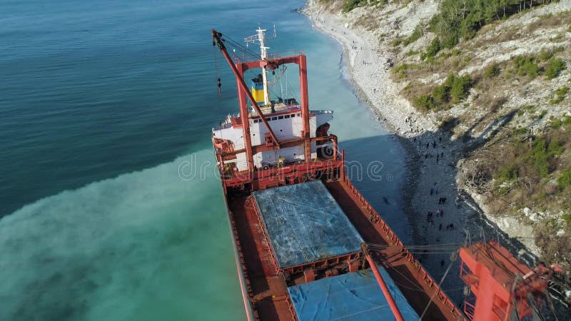 Vista superior aérea de uma barca vazia, vermelha amarrada perto da costa de mar azul bonita Posição industrial grande do navio p