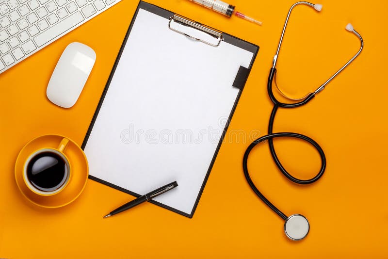 Vista superior da tabela de um doutor com bloco de notas e estetoscópio da pena, teclado, prescrição e comprimidos, uma xícara de foto de stock Vista superior da tabela de um doutor com bloco de notas e estetoscópio da pena, teclado, prescrição e comprimidos, uma xícara de foto de stock