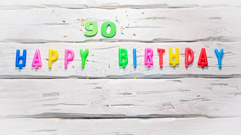 Top view of happy birthday candle numbers copy space on wooden white pastel boards. Beautiful birthday card with number 90. Top view of happy birthday candle numbers copy space on wooden white pastel boards. Beautiful birthday card with number 90