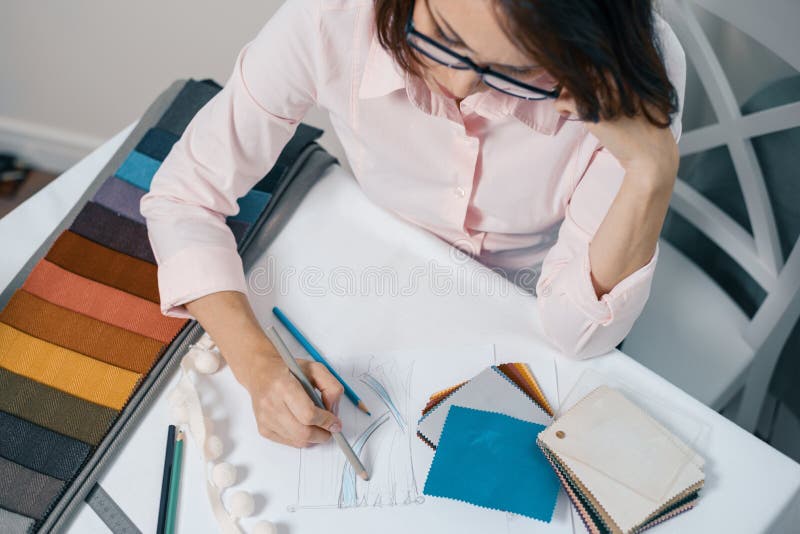 Vista superior de la cortina de dibujo del diseñador de la mujer del lugar de trabajo y de la tela el elegir para el interior imagen de archivo libre de regalías Vista superior de la cortina de dibujo del diseñador de la mujer del lugar de trabajo y de la tela el elegir para el interior imagen de archivo libre de regalías