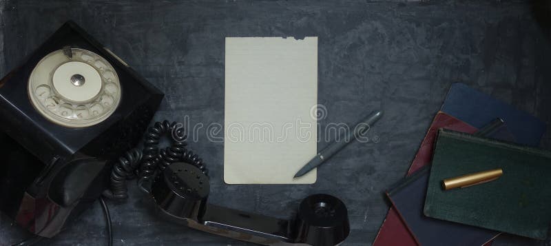 Vista superior de página y bolígrafo en blanco, teléfono negro obsoleto, viejos cuadernos en una superficie decorativa gris oscur imagen de archivo libre de regalías Vista superior de página y bolígrafo en blanco, teléfono negro obsoleto, viejos cuadernos en una superficie decorativa gris oscur imagen de archivo libre de regalías