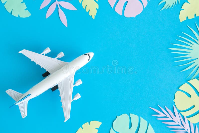Vista superior do modelo do avião e das folhas coloridos contra o fundo azul imagens de stock Vista superior do modelo do avião e das folhas coloridos contra o fundo azul imagens de stock