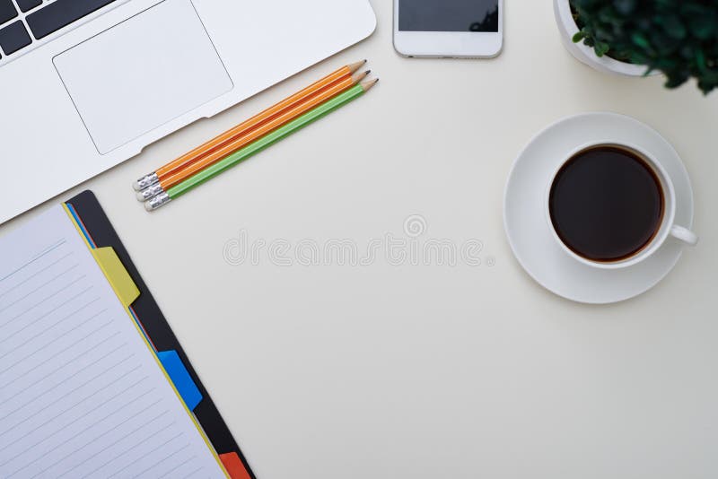 Vista superior de um portátil, bloco de notas, lápis, smartphone e chávena de café foto de stock royalty free