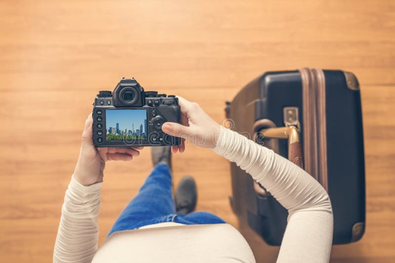 Vista superior em uma menina que olha uma cidade de Chicago das fotos em sua posição da câmera com a mala de viagem no aeroporto fotos de stock Vista superior em uma menina que olha uma cidade de Chicago das fotos em sua posição da câmera com a mala de viagem no aeroporto fotos de stock