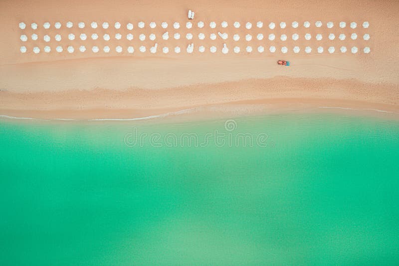 Vista superiore aerea sulla spiaggia Ombrelli, sabbia ed onde del mare immagine stock Vista superiore aerea sulla spiaggia Ombrelli, sabbia ed onde del mare immagine stock